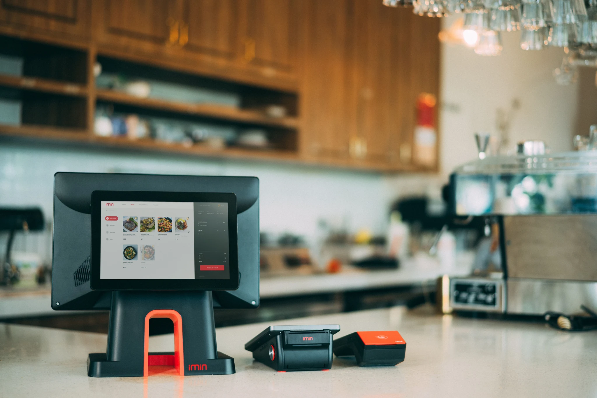 Restaurant checkout counter showing an iMin POS terminal and a small handheld payment device next to it