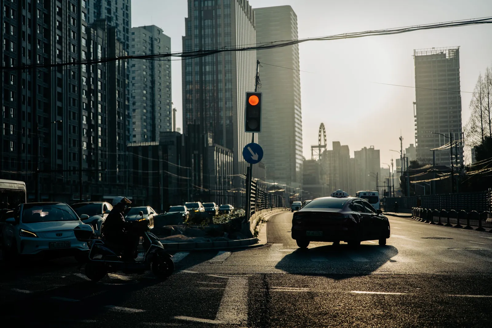 Evening traffic on a Shanghai road at dusk, cars queued at a junction.
