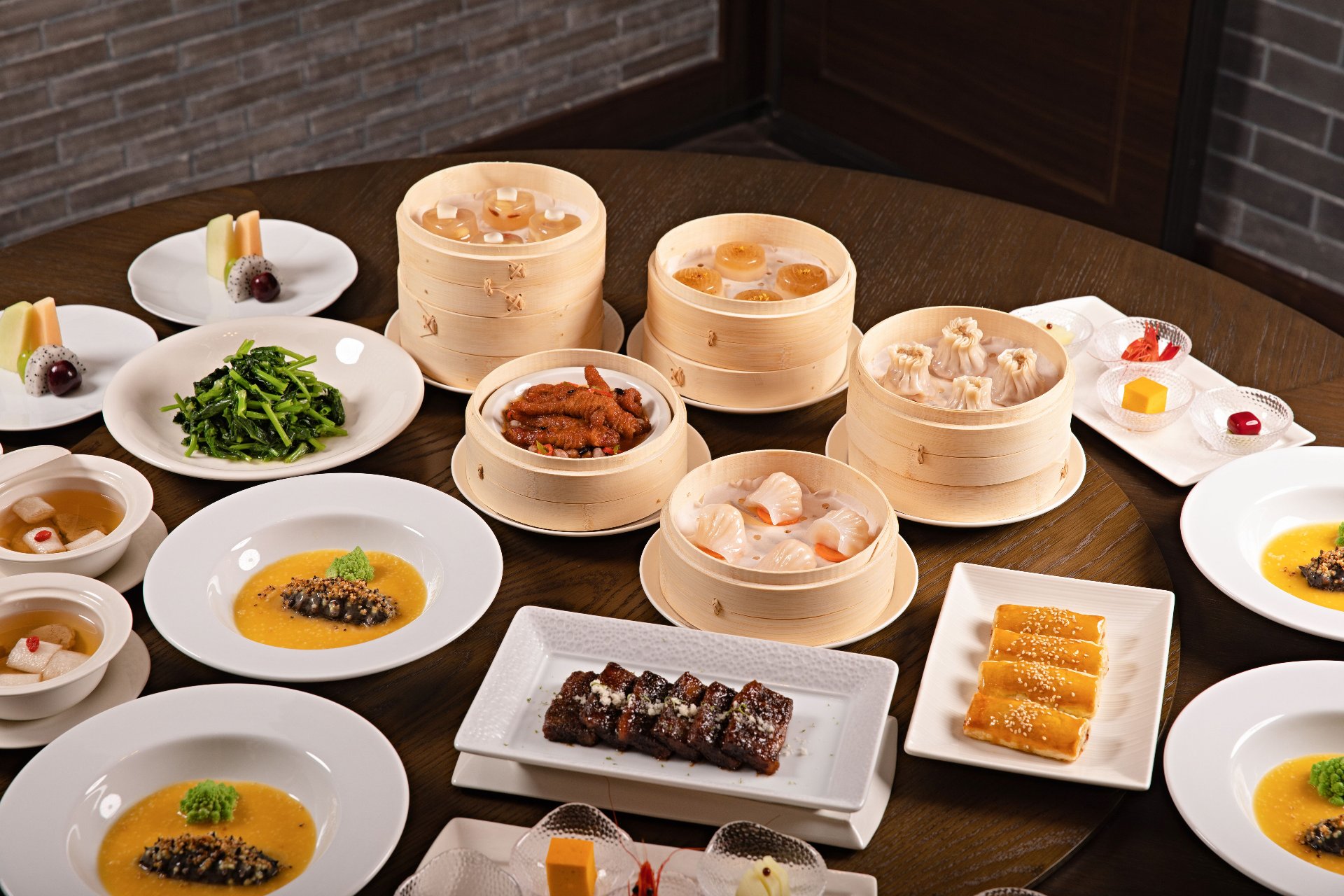 A full Cantonese dim sum spread with steamer baskets of har gow and siu mai, barbecue pork, congee and classic desserts — the hallmark of Guangzhou's morning food culture