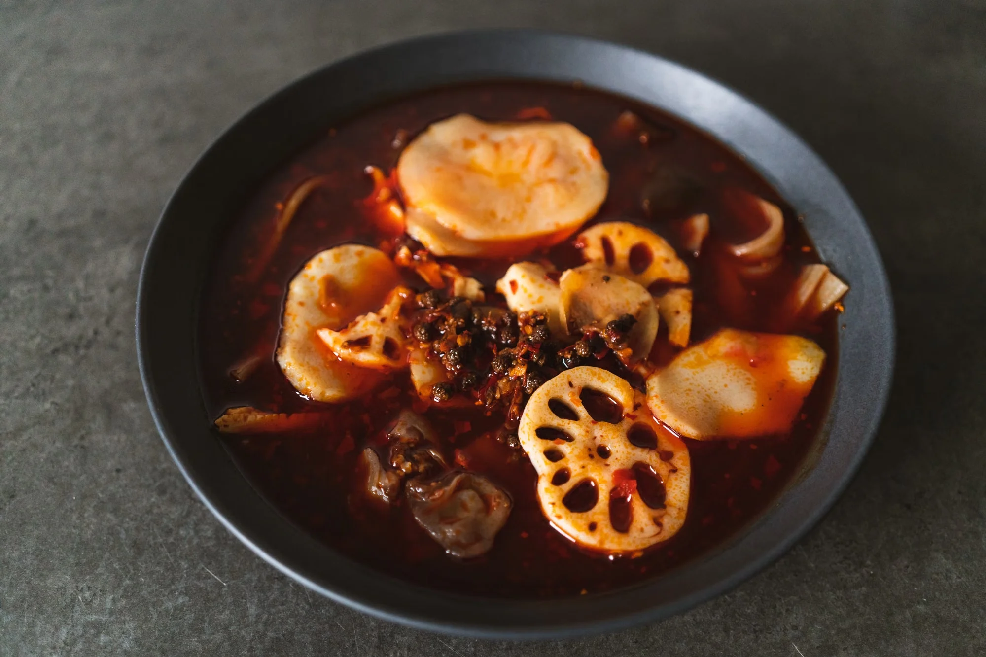 A bowl of fiery Sichuan vegetables in chili oil