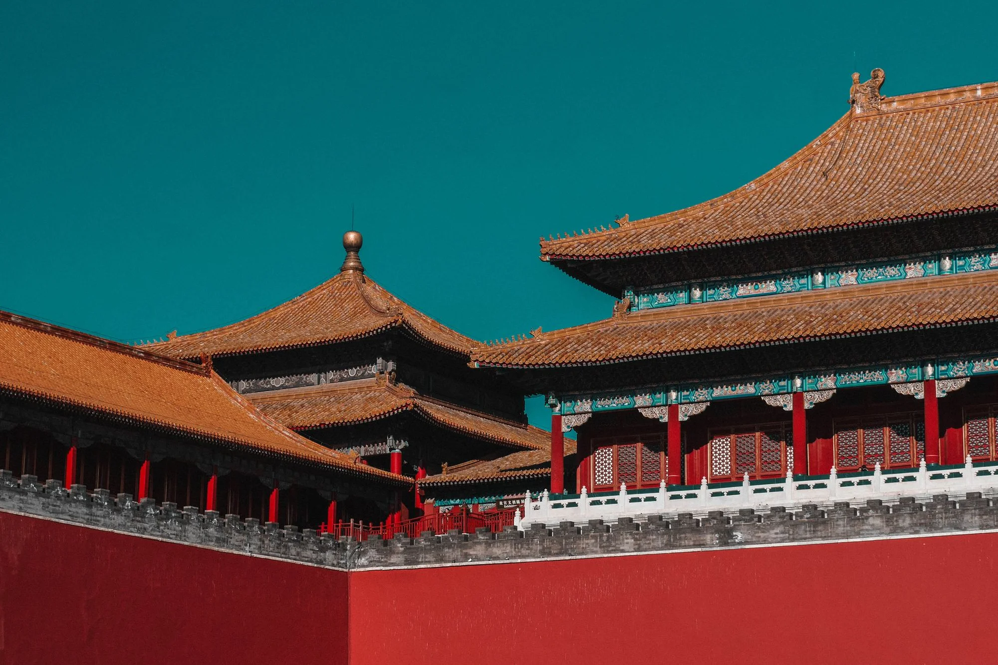 The Forbidden City's red walls and golden roofs under a clear blue sky