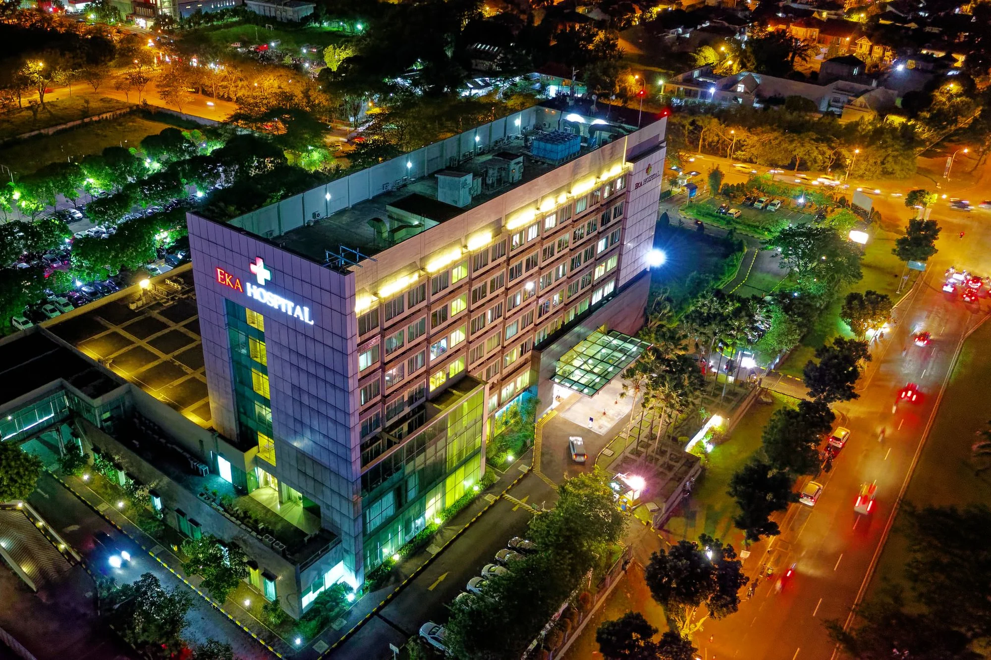 The lit entrance of a modern hospital building in China at night
