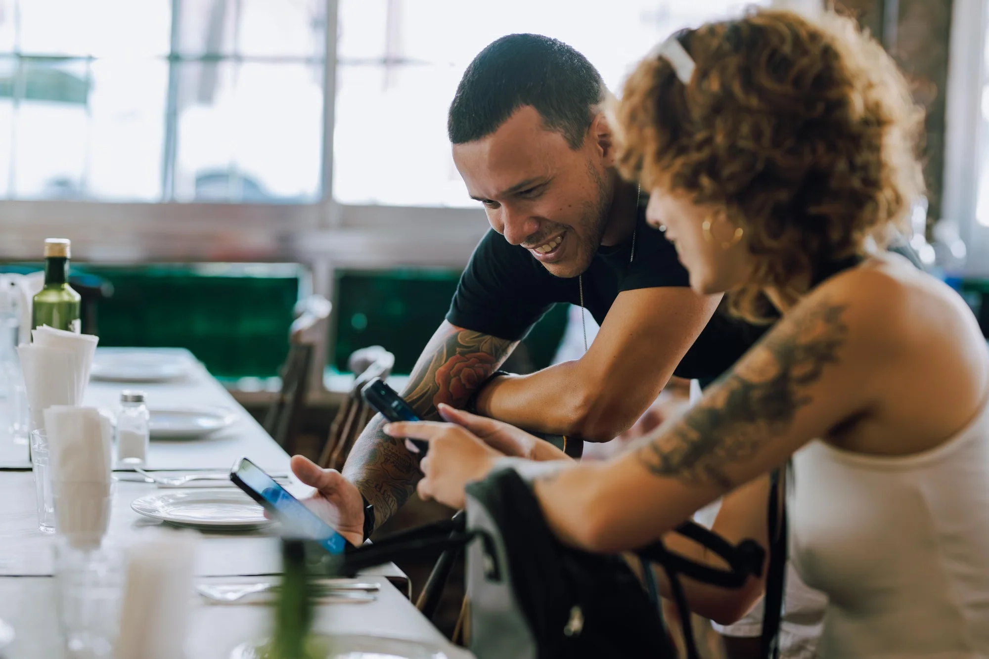 A group of friends sharing one pocket WiFi at a restaurant table, phones and a tablet connected