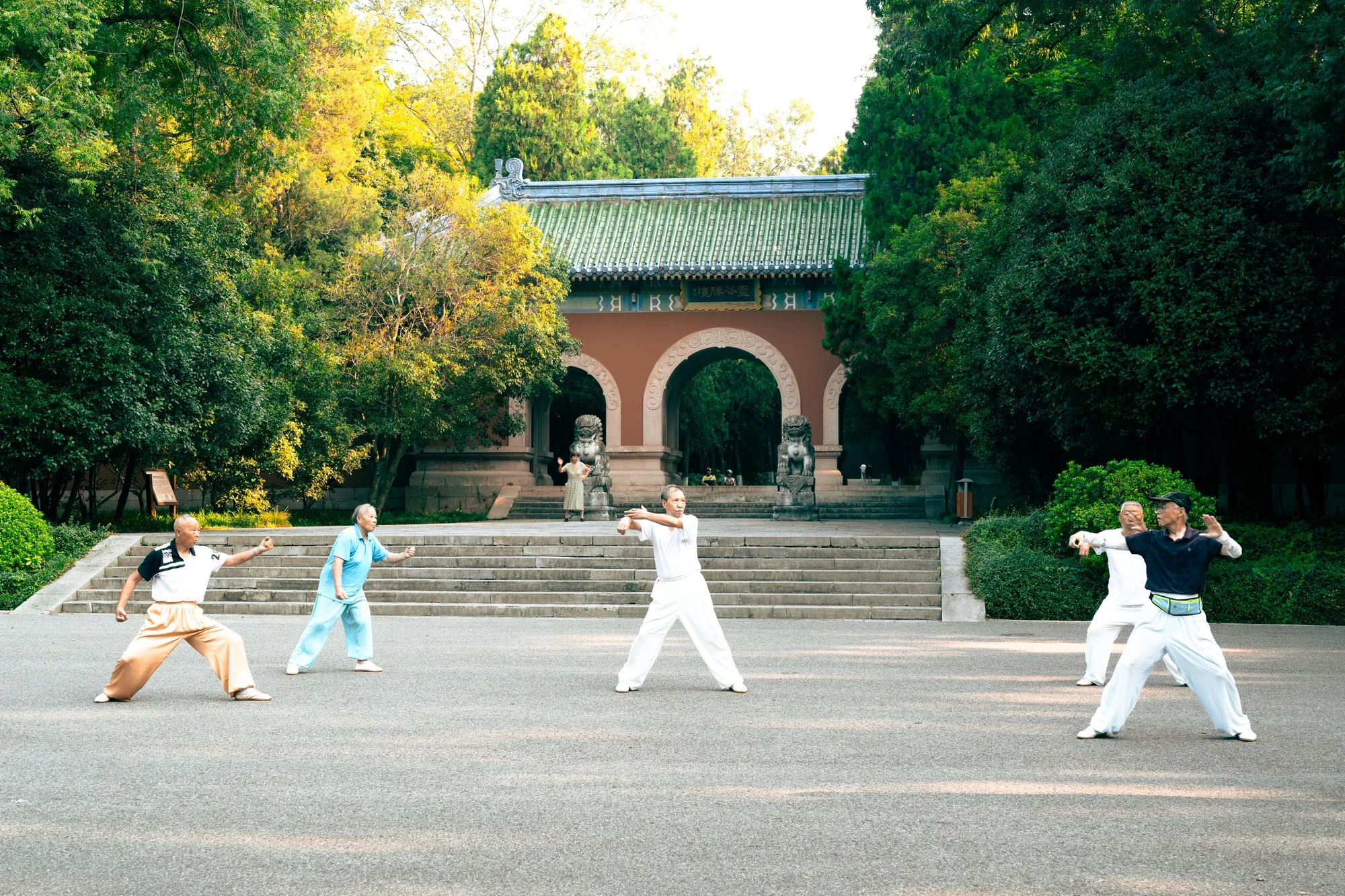 People exercising together with tai chi and fans in a Chinese park at morning