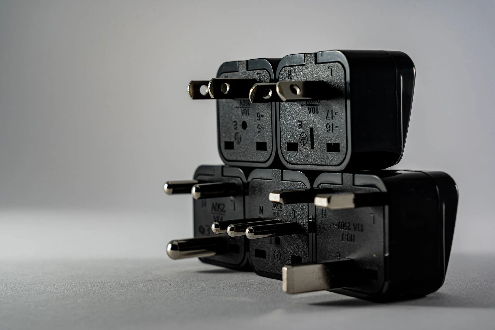 A pile of international travel power adapters in different plug shapes