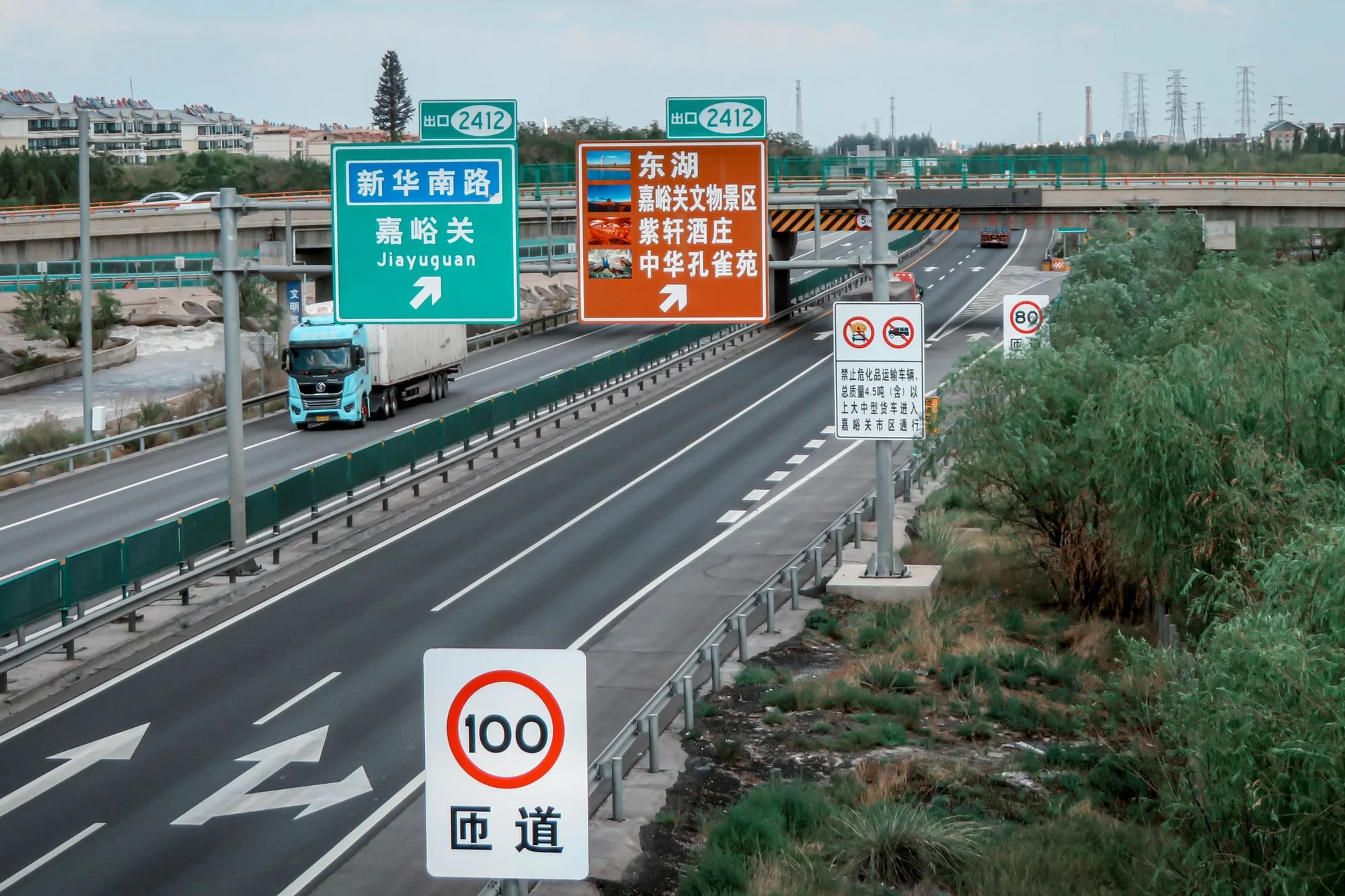 Expressway signage near Jiayuguan, China, on a route where visitors drive on a temporary driving permit