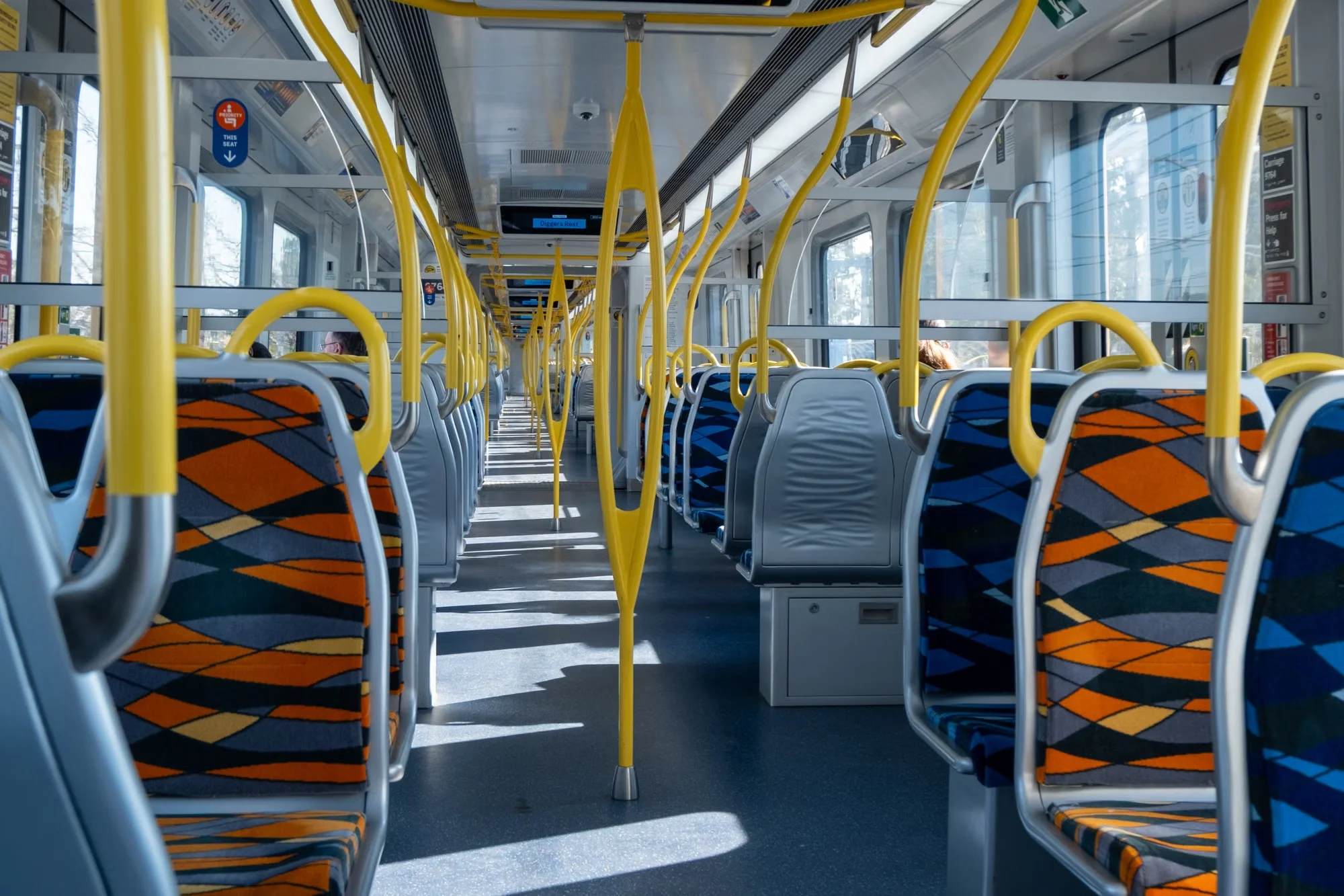 Interior of a modern Chinese high-speed train carriage with colorful seats and yellow handrails stretching into the distance