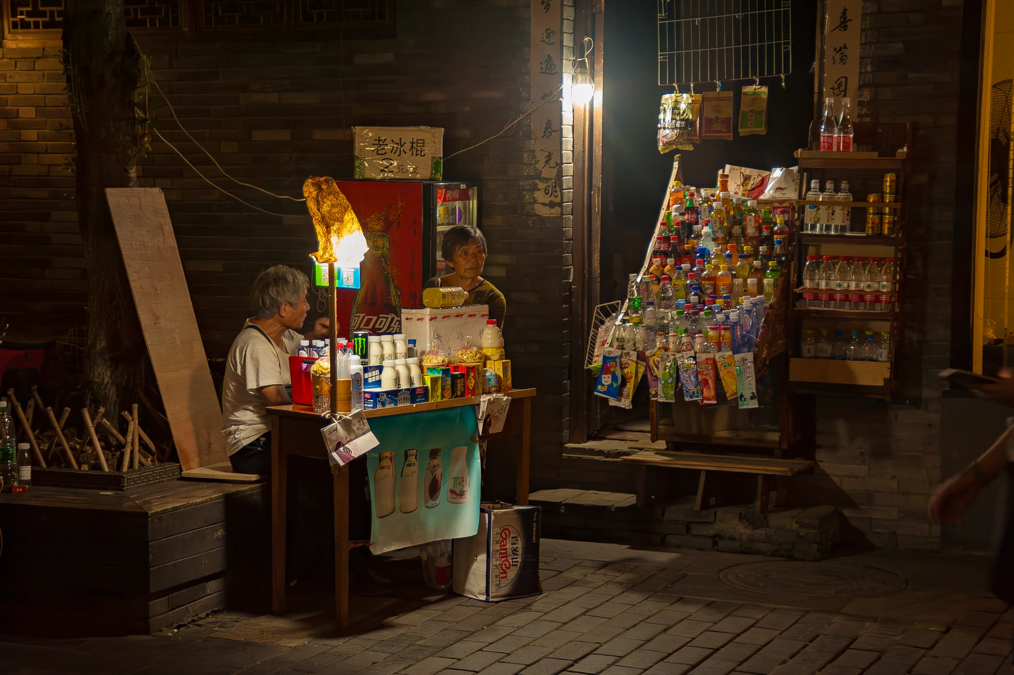 A tiny late-night convenience store in China lit by a single bulb